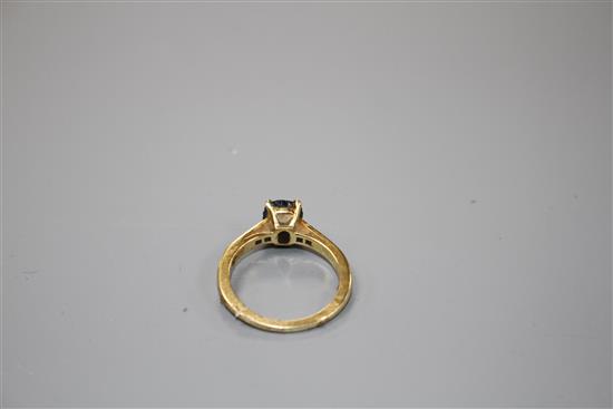 A modern 18ct gold and oval cut sapphire ring, with diamond set shoulders, size M, gross weight 3.4 grams.